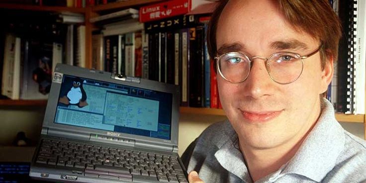 A photo of a young Linus Torvalds holding his computer running Linux